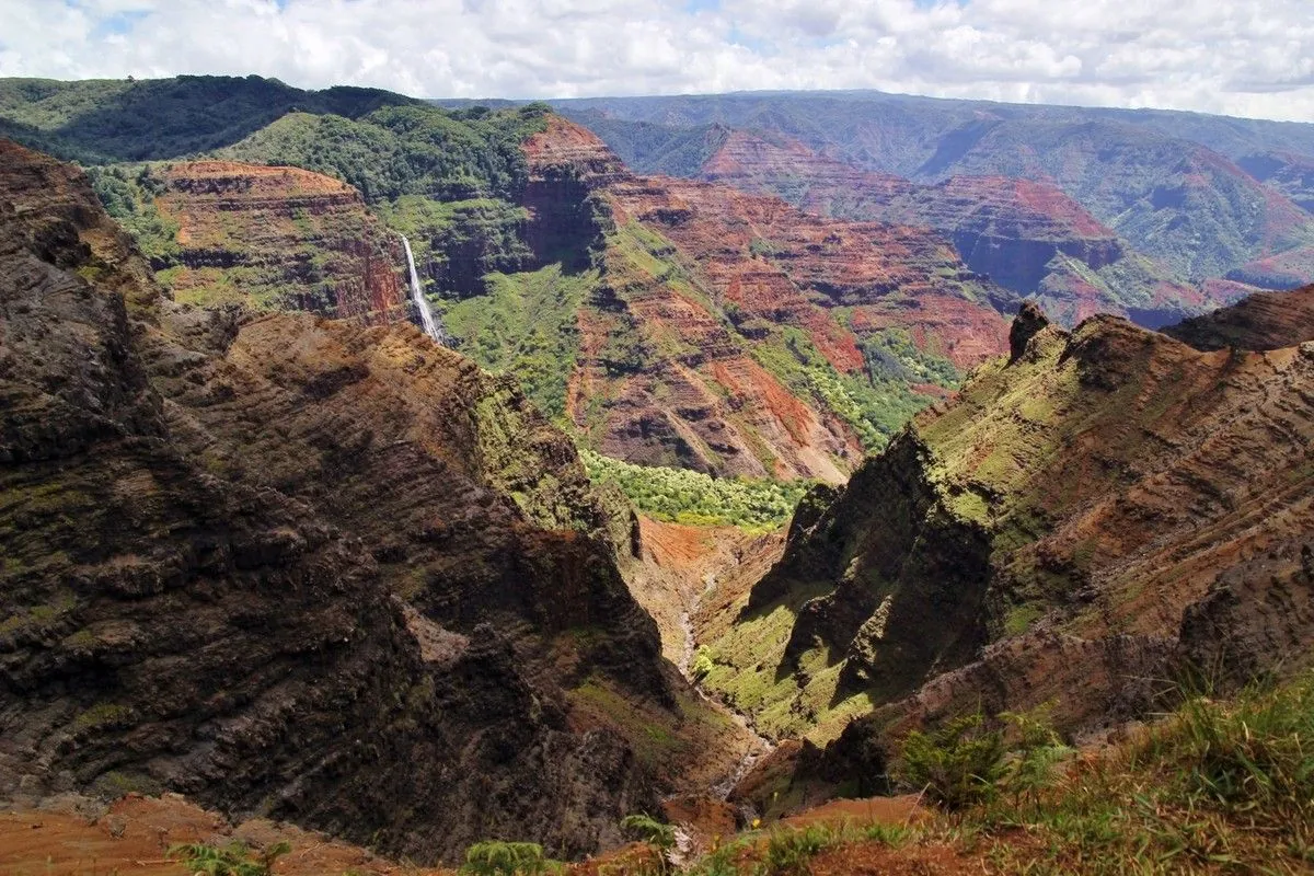 Gorge profonde du canyon de Waimea avec une fine cascade en arrière-plan, à Kaua'i